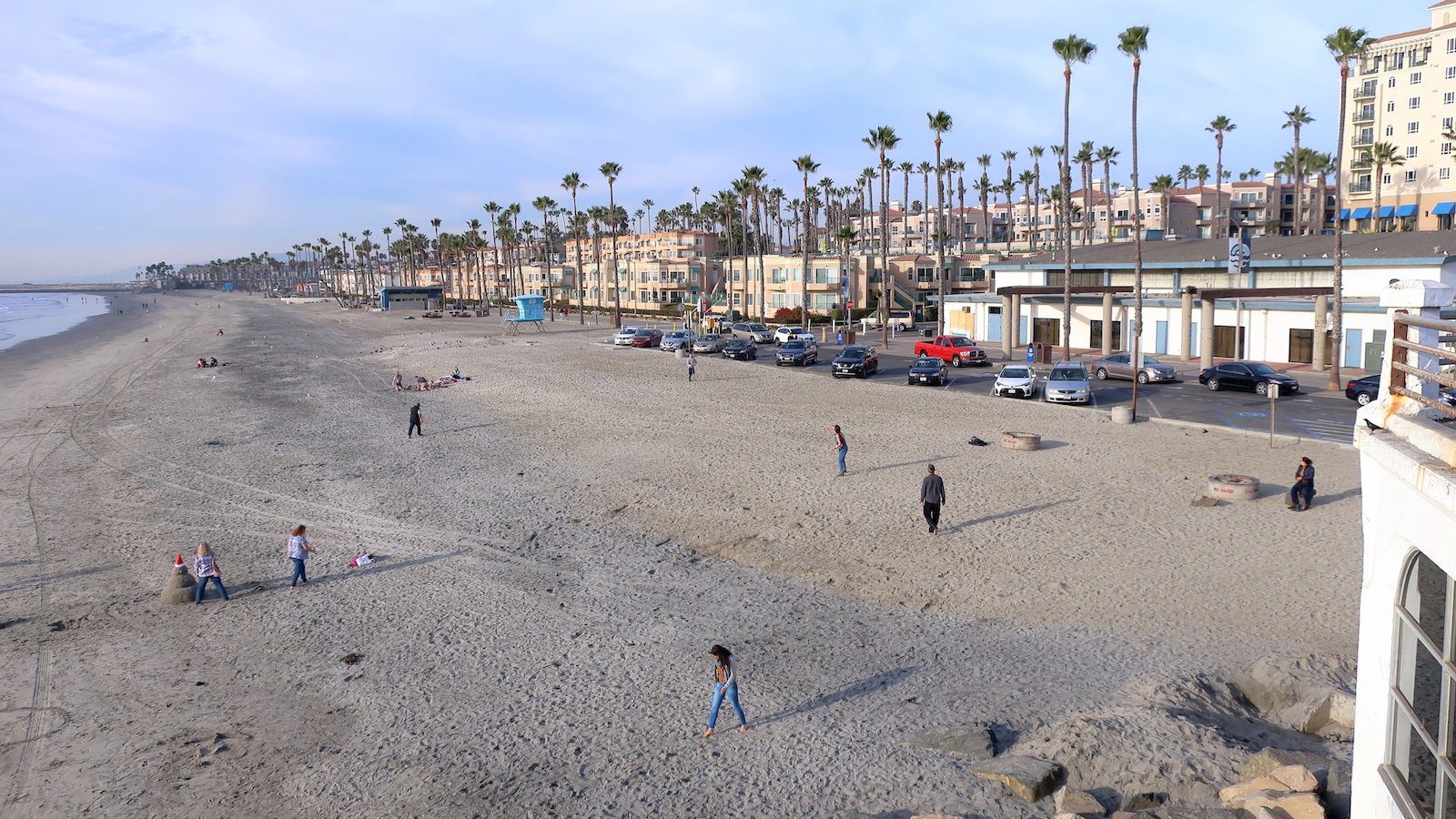 Image of visitors walking along Oceanside Beach, CA